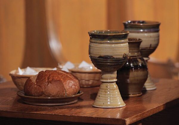 Ceramic goblets and bread on a wooden table.