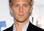 Young blond man in blazer, open-collar shirt