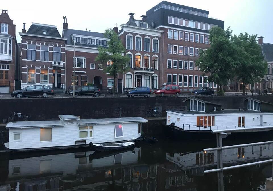 Houseboats moored along canal with historic buildings