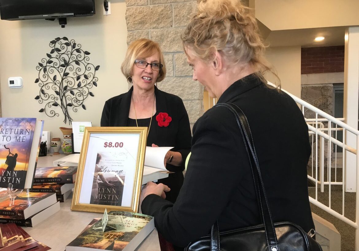 Book signing table with two women interacting