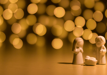 A small angel figurine with glowing bokeh lights in the background.