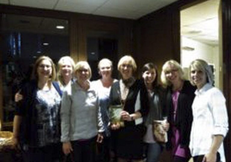 Group of smiling women posing indoors
